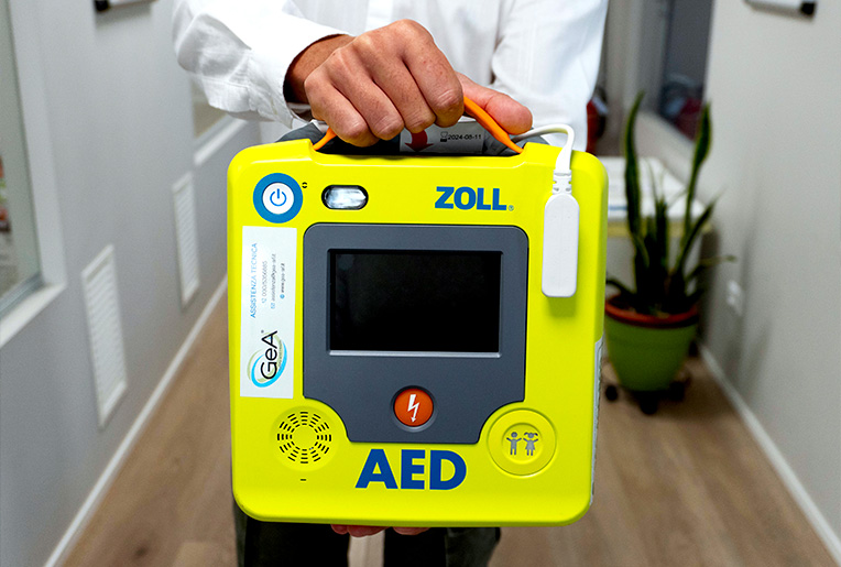 Personale di GeA srl porge un Defibrillatore DAE Zoll